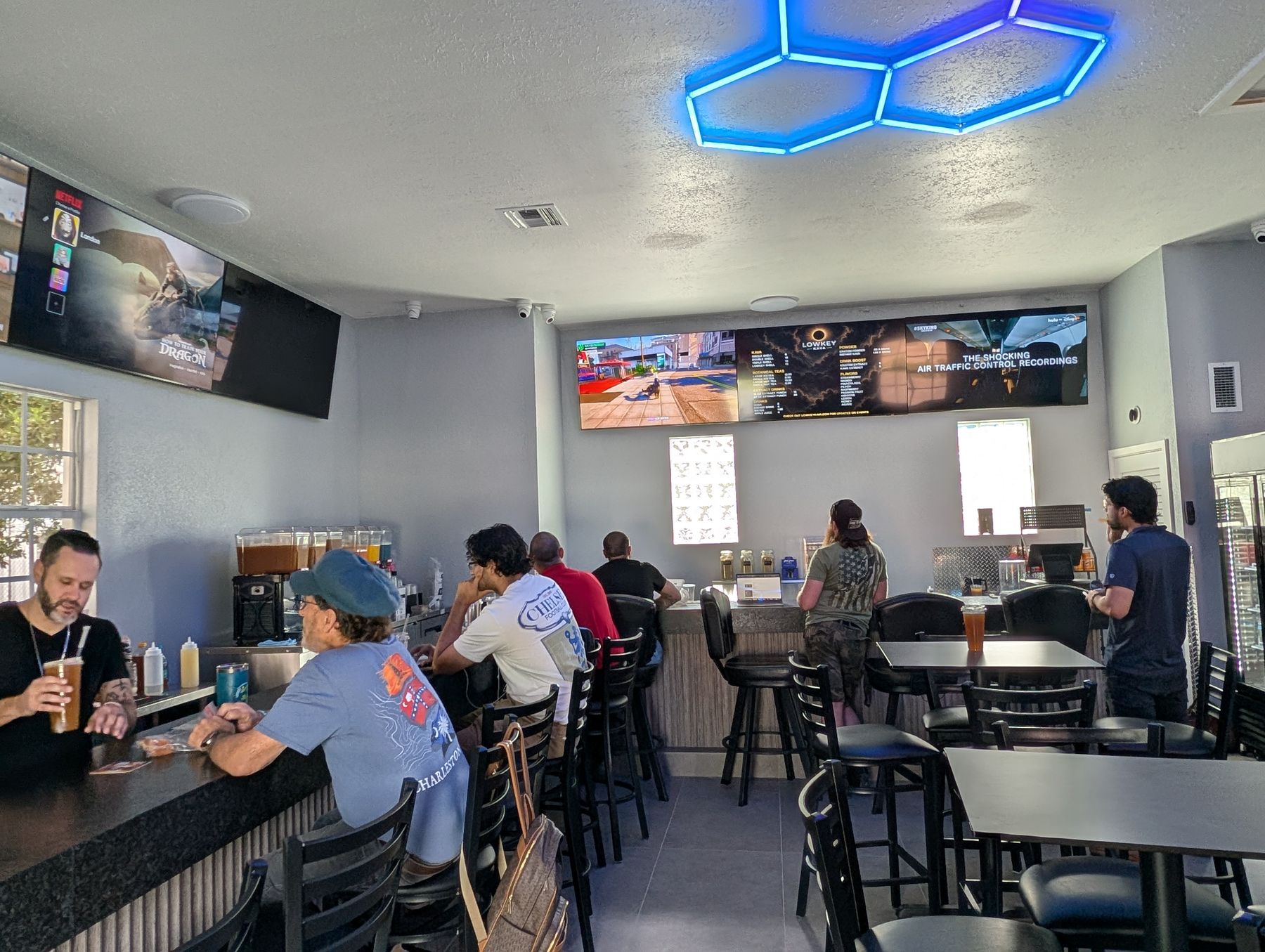 Inside the full bar at Lowkey Kava with big-screen TVs and lounge seating