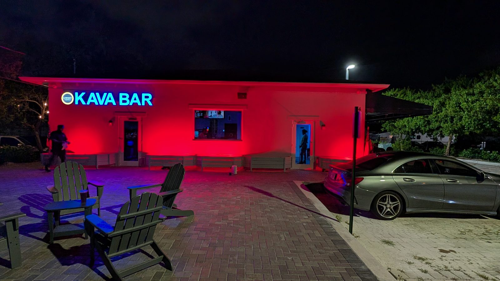 Lowkey Kava's KAVA BAR sign glowing at night with red-lit exterior and patio seating, 404 S Military Trail West Palm Beach