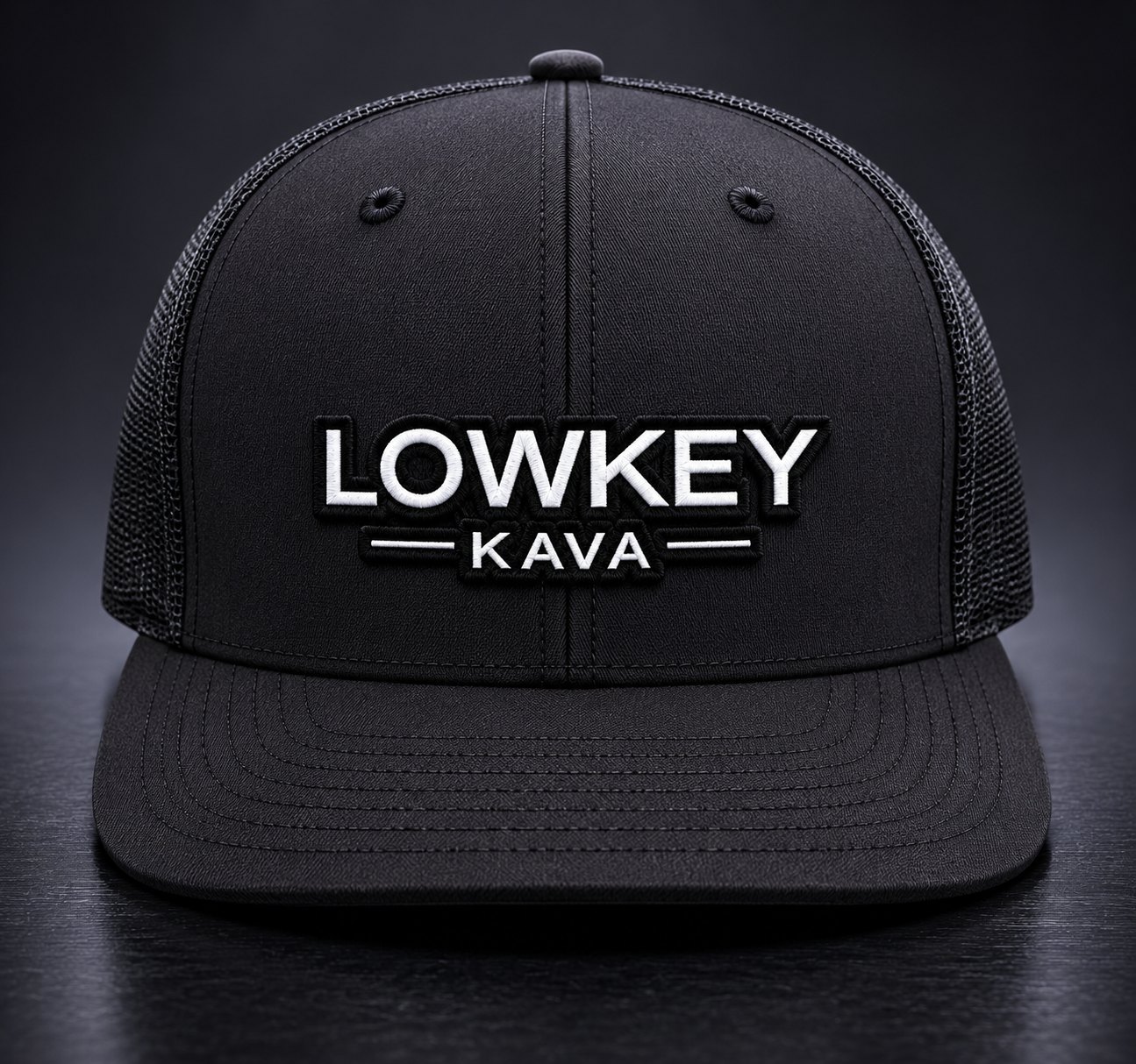 The official Lowkey Kava snapback hat &mdash; black trucker style with white embroidered LOWKEY KAVA patch